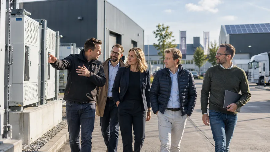 Betrokkenen in gesprek bij een batterijcontainer op een bedrijventerrein