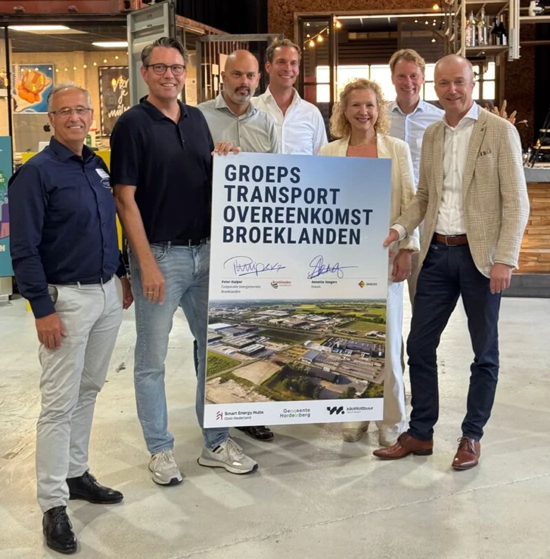 Ondertekening van de groepstransportovereenkomst op Broeklanden: betrokkenen bij het bord met de handtekeningen van Coöperatie Energieterrein Broeklanden en Enexis
